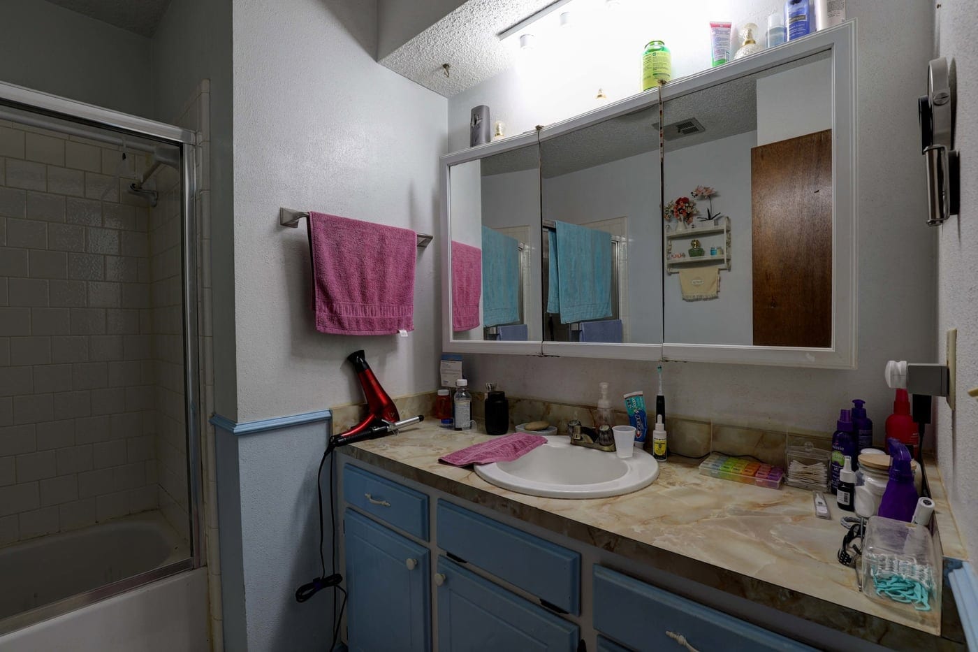 Blue vanity and framed tub door before the remodel