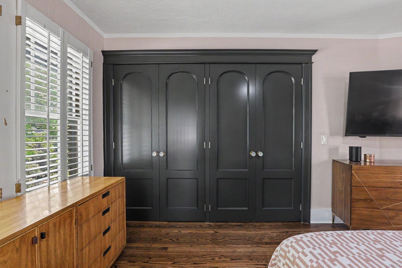 Primary bedroom with custom built-in black wardrobe