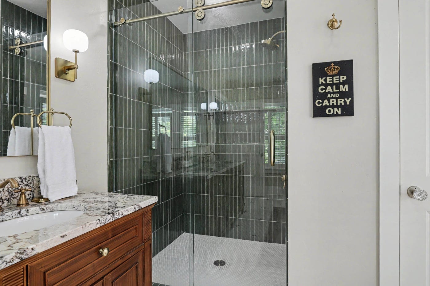 Walk-in shower with green vertical tile and glass enclosure