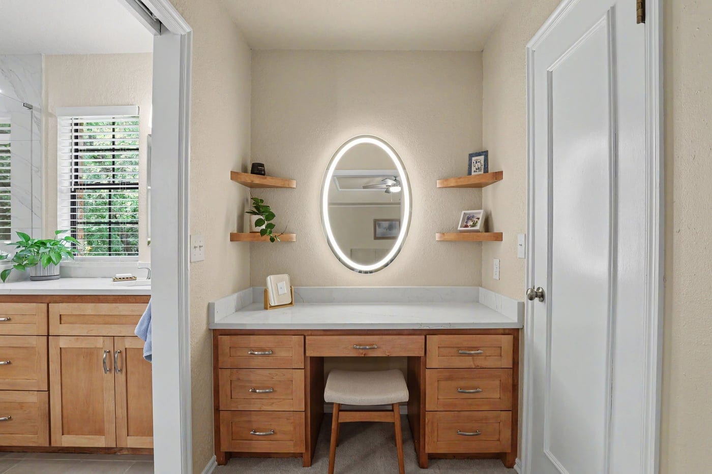 Remodeled makeup vanity with backlit oval mirror and floating shelves