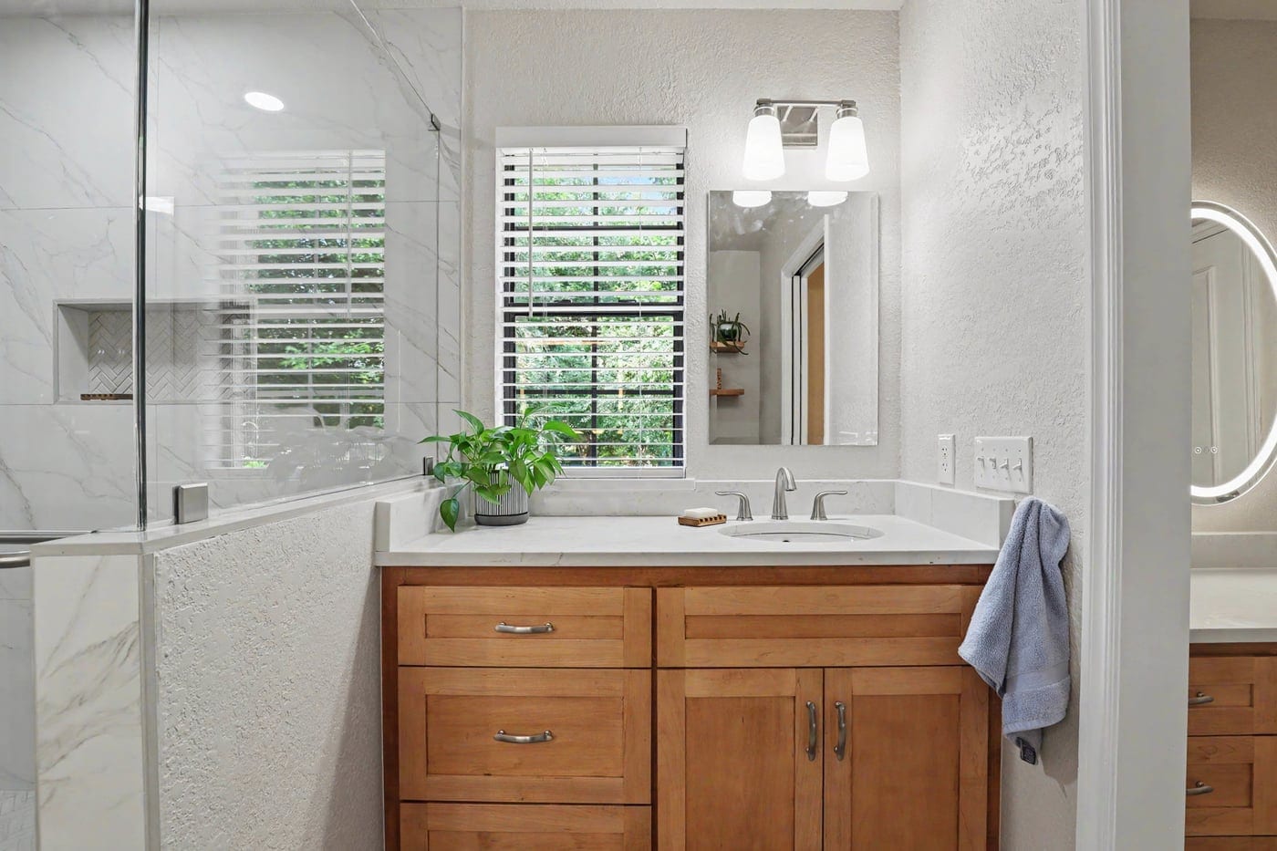 Remodeled bathroom in Edmond, OK with glass walk-in shower and wood vanity
